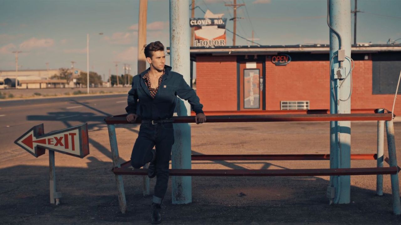 a man leaning on a railing next to an exit sign